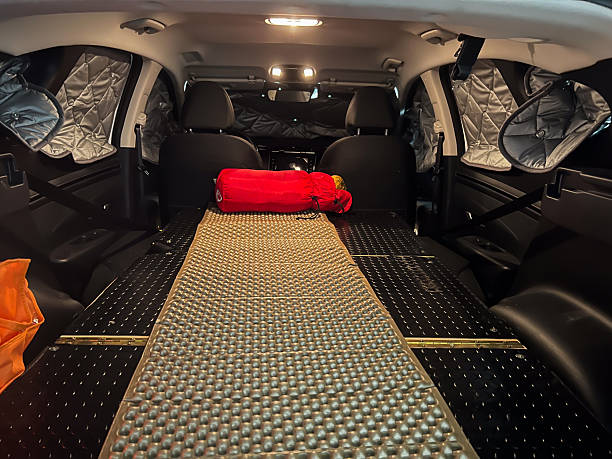 Olot, Spain; July 12 2023: SUV interior converted for sleeping, featuring a custom platform, insulation, and red sleeping bag