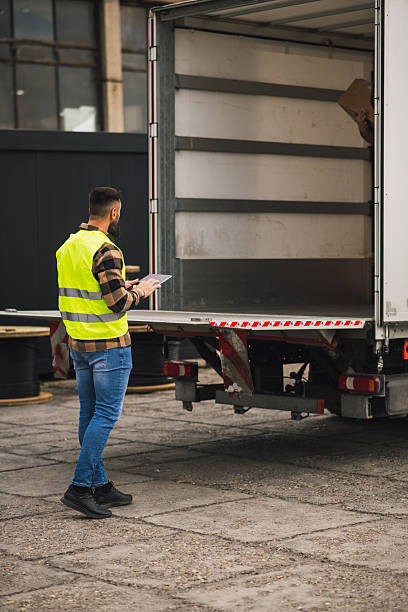 istock Worker in safety vest controlling delivery process with tablet 2244815544