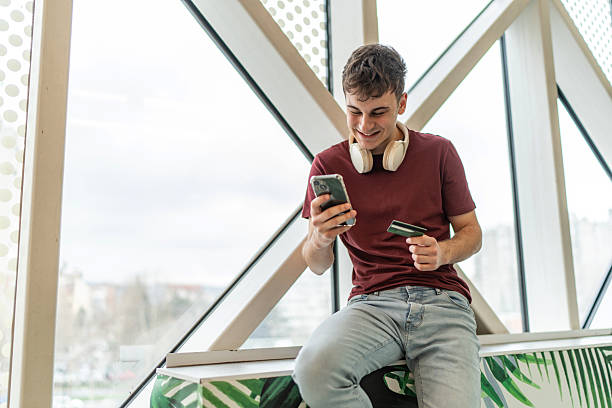 istock Young man online shopping using smartphone and credit card 2244817017