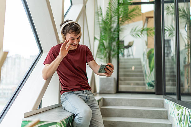 istock Young man having video call wearing headphones 2244817154