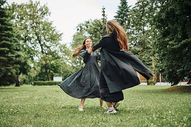 istock Two young women dancing joyfully on green lawn in park 2244819437