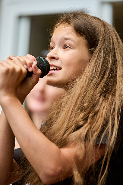 istock Young girl singing passionately into microphone indoors 2244819496