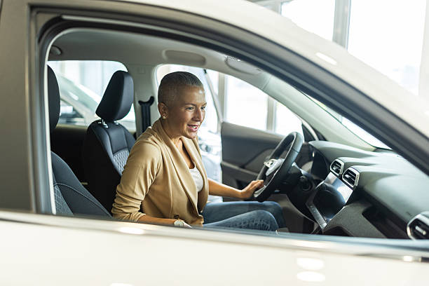 istock Confident Woman Driving a Car Inside a Modern Showroom With Smiling, Focused Expression 2244821158