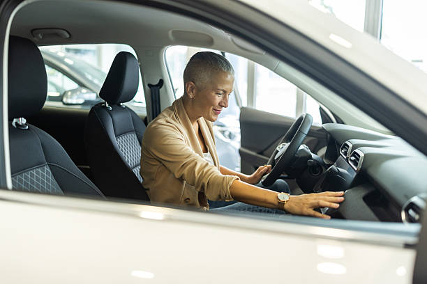 istock Confident Woman Driving a Car Inside a Modern Showroom With Smiling, Focused Expression 2244821199
