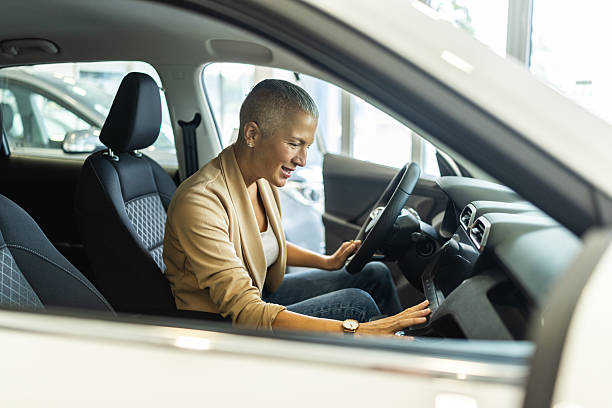 istock Confident Woman Driving a Car Inside a Modern Showroom With Smiling, Focused Expression 2244821247