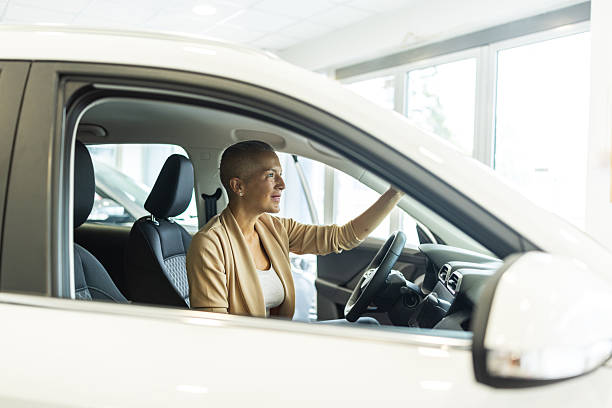 istock Confident Woman Driving a Car Inside a Modern Showroom With Smiling, Focused Expression 2244821354