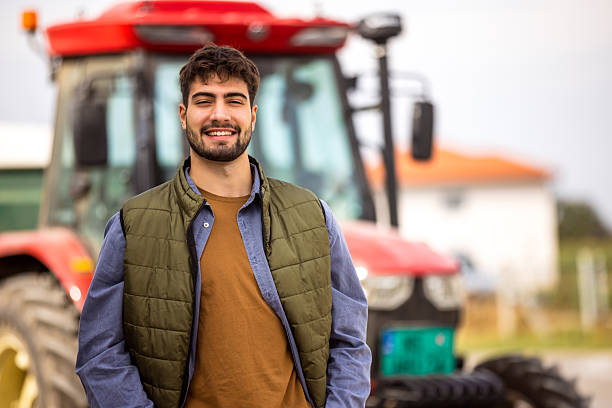 istock Young tractor driver smiling in front of tractor 2244825006