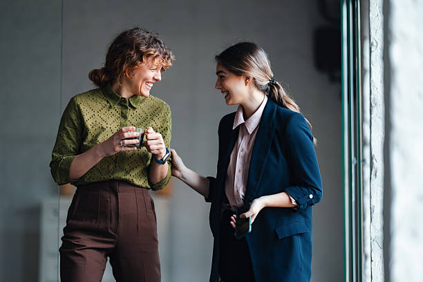 istock Friendly Office Conversation Between Two Women Colleagues Sharing Coffee in a Modern Workspace 2244825163