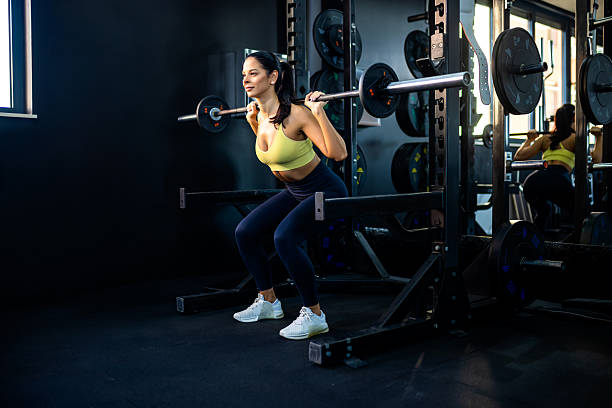 istock Young woman doing weighted squat on smith machine 2244830032