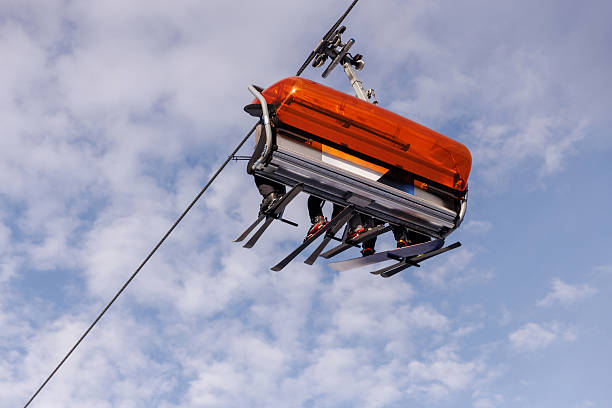 istock Skiers on modern chairlift against blue sky 2244835332