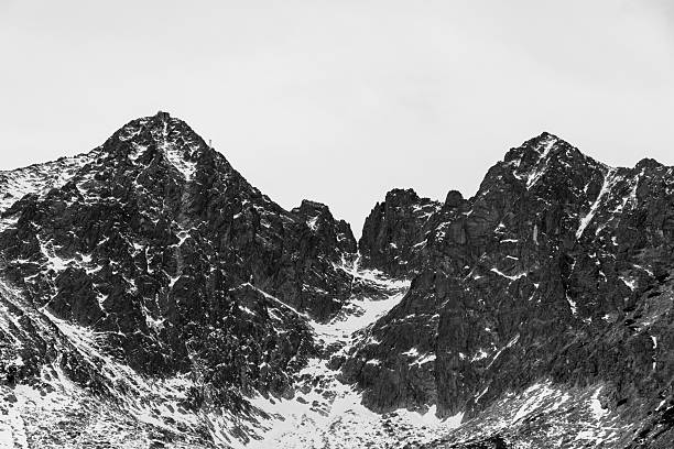 istock Black and white winter mountain peaks with snow patches 2244835351