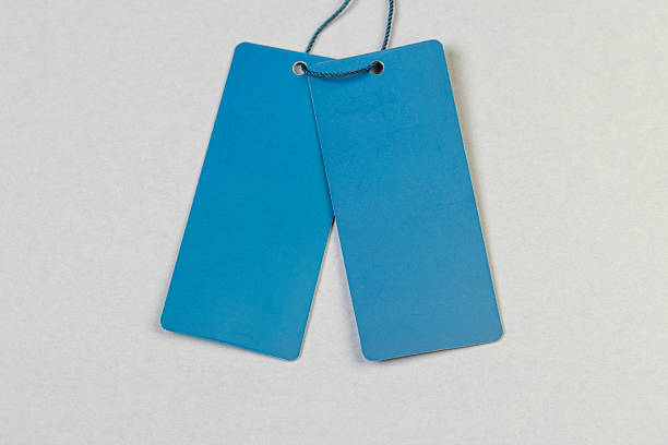 a blue empty tag for indicating the price and other information, an old clothing tag that is not filled in, which contains information important to customers