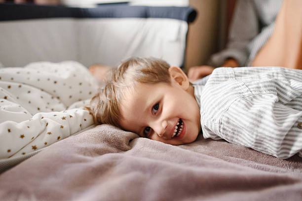 istock Smiling Toddler Lying On Bed At Home 2244836238