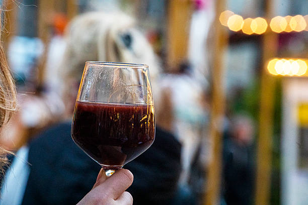 Drinking hot punch from a glass at a street fair.