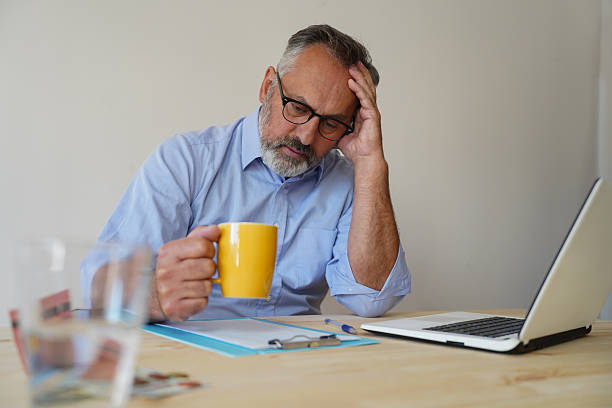 istock Middle-aged man working on a laptop, managing finances, sitting at a desk 2244841606