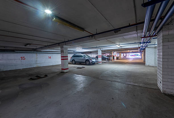istock Empty Underground Parking Garage with Parked Cars and Illuminated Ceiling 2244842012