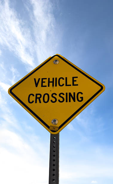 istock Yellow vehicle crossing warning sign against blue sky 2244843498