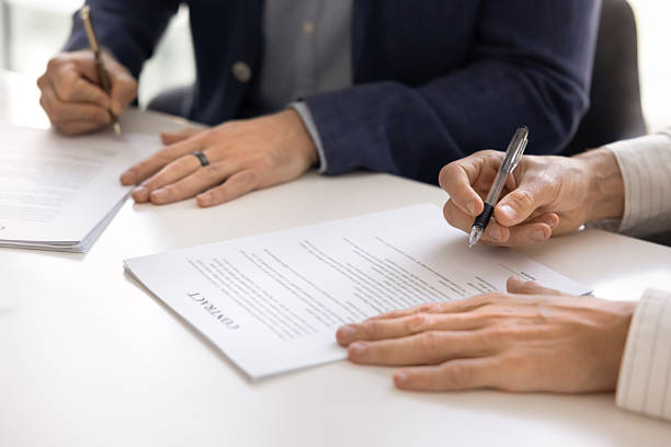 istock Two male business partners signing contract at large table 2244843629