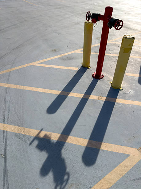 istock Red fire hydrant standing in parking lot with long shadows 2244844362