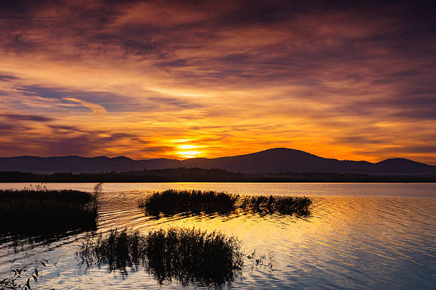 istock Sunset Over Calm Lake with Mountain Silhouette 2244845216