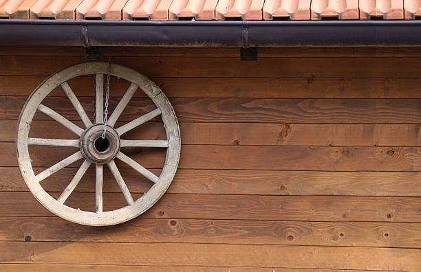 two old wagon wheels on a weathered wooden barn wall