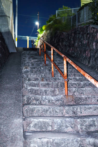 istock Night stone steps with a rusty handrail leading up an alley 2244845893