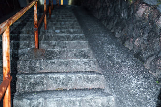 istock Night stone steps with a rusty handrail leading up an alley 2244845909