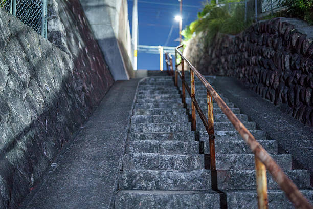 istock Night stone steps with a rusty handrail leading up an alley 2244845942