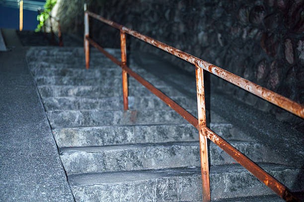 istock Night stone steps with a rusty handrail leading up an alley 2244845969