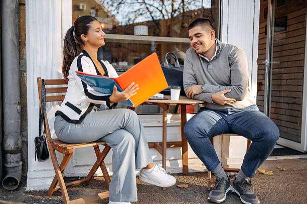 istock Two young business colleagues spending time together outside while on a break sitting in sidewalk cafe 2244847675