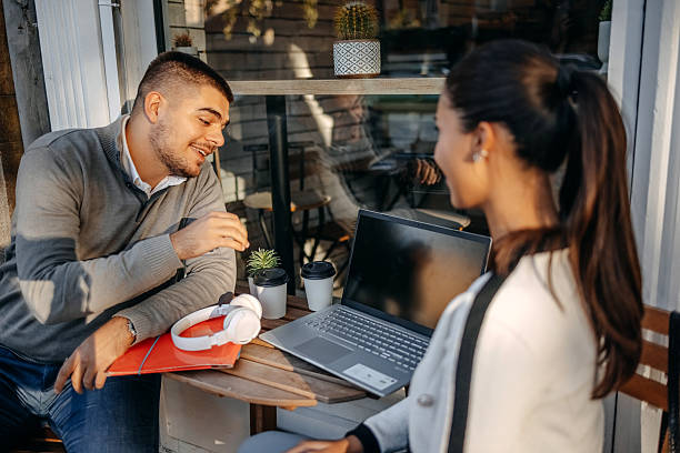 istock Two young business colleagues spending time together outside while on a break sitting in sidewalk cafe 2244847701