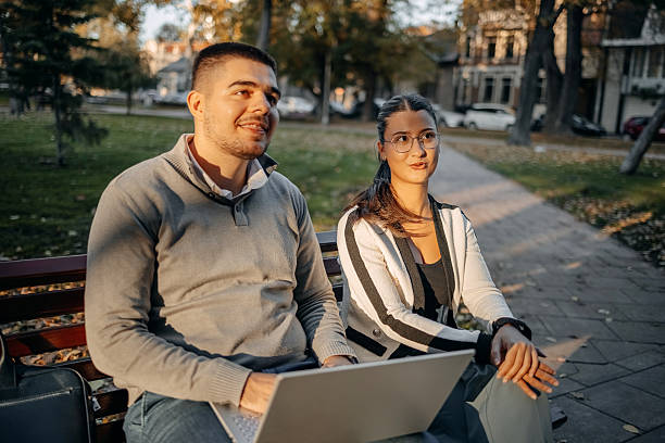 istock Two young business colleagues spending time together outside while on a break and looking at laptop 2244847787