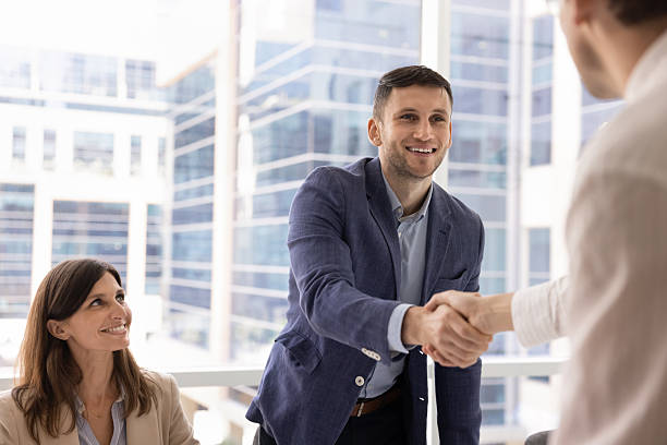 istock Positive young businessman shaking hands with business partner 2244852084