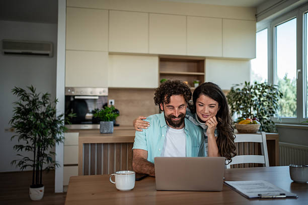 istock Couple sharing laptop creating happy home lifestyle 2244852397