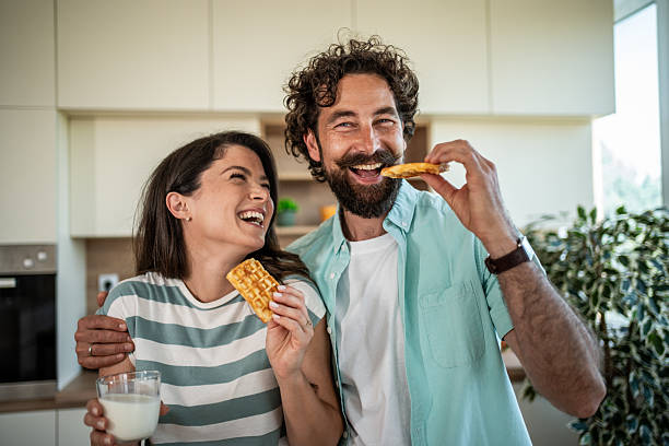 istock Cheerful couple enjoying breakfast waffles and milk together 2244854356