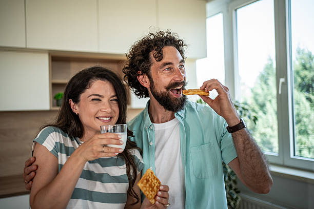 istock Happy couple enjoying breakfast waffles and milk in kitchen 2244854377