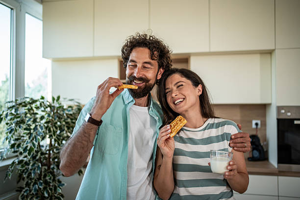 istock Happy young couple enjoying waffles and milk for breakfast 2244854394