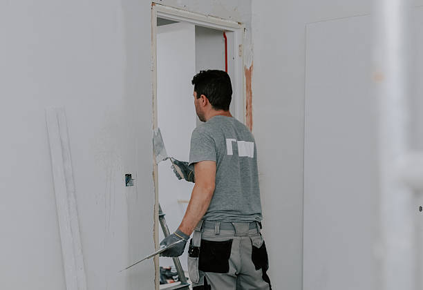 istock One young man covers up a crack in the doorway. 2244857769