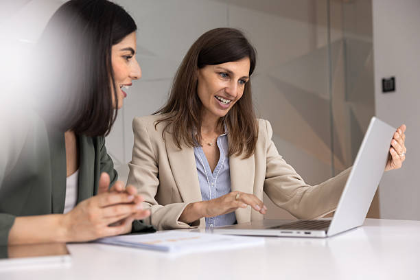 istock Two positive female coworkers using laptop computer for teamwork 2244858056