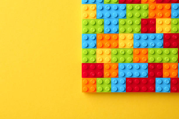 istock Constructor toy. Many colorful building blocks on yellow background, top view. Space for text 2244863324
