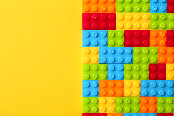 istock Constructor toy. Many colorful building blocks on yellow background, top view. Space for text 2244863389