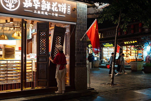 Dali, China - October 10, 2025: Outdoor night view of street in Dali Ancient Town, with traditional architecture and people.