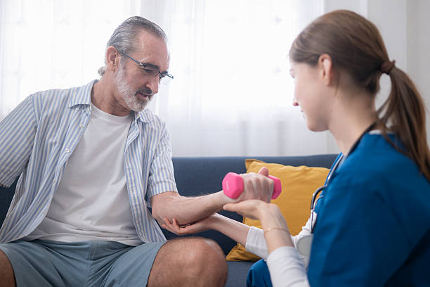 istock Female physiotherapist assisting an elderly man with arm strength training 2244879087