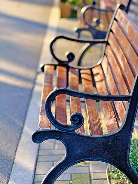 istock park chair beside pathway in sunlight 2244890655