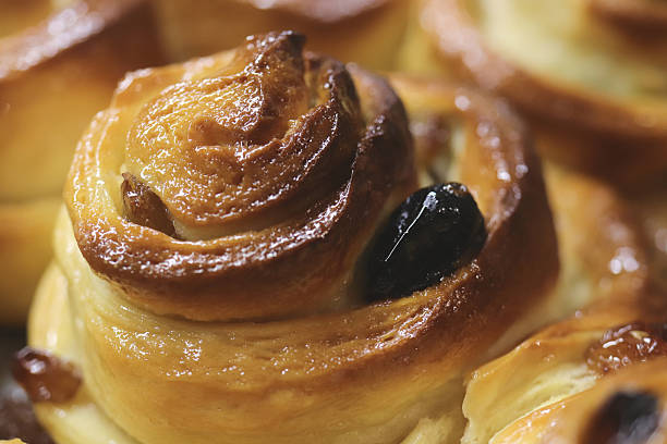 Close-up of freshly baked cinnamon rolls with raisins.