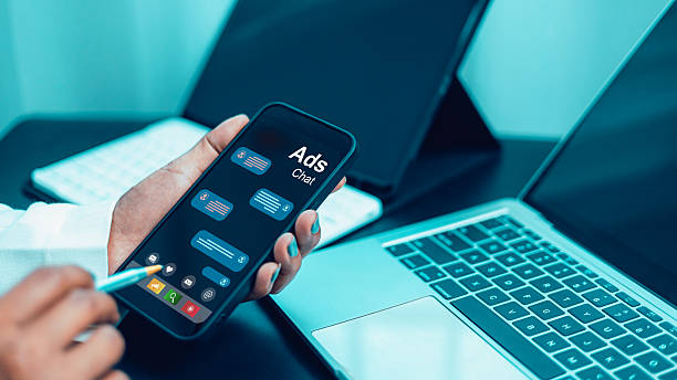 istock Businessman using smartphone with ads chat app on screen for digital marketing in modern office 2244895036