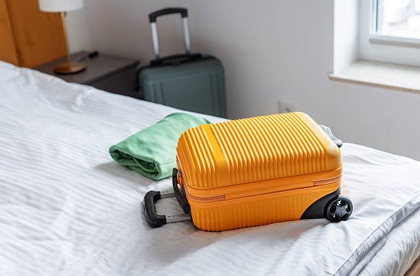 istock Orange suitcase and folded clothes resting on hotel bed 2244900912