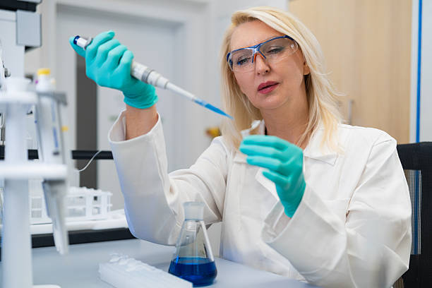 istock Scientist woman preparing solution with pipette and test tube 2244901702