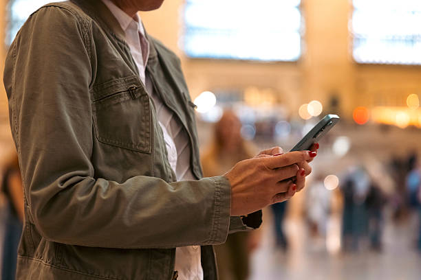 istock Woman texting on mobile in a busy area 2244907452