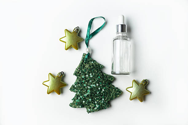 istock Cosmetic serum and sequin christmas tree shaped ornament on white background 2244907574